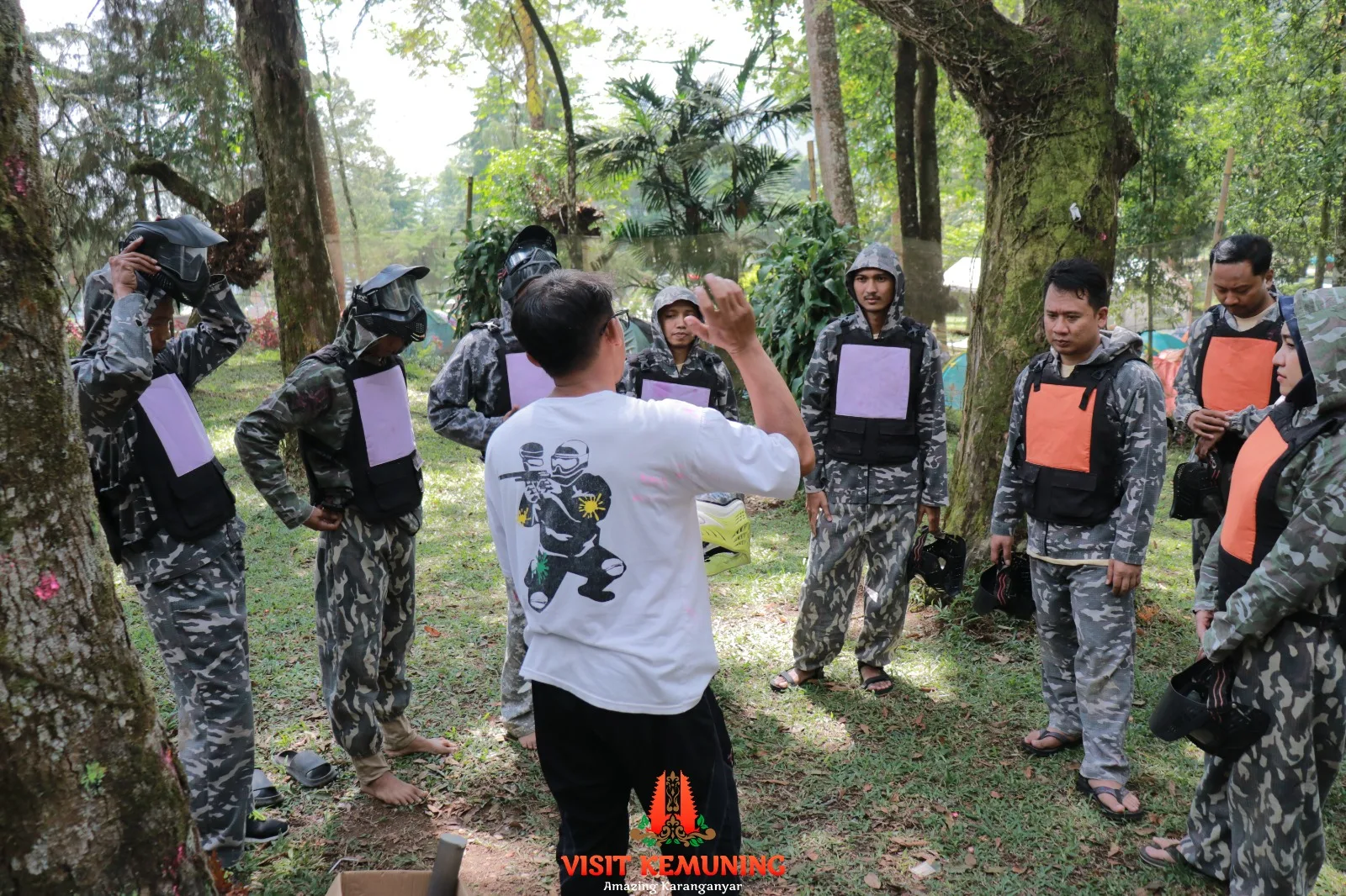 Tim berdiskusi mengatur strategi di sela pertandingan paintball di Kemuning