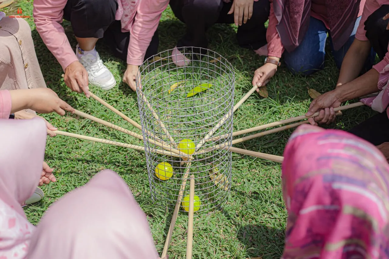 Tim perusahaan menyelesaikan tantangan bersama dalam sesi team building di Kemuning