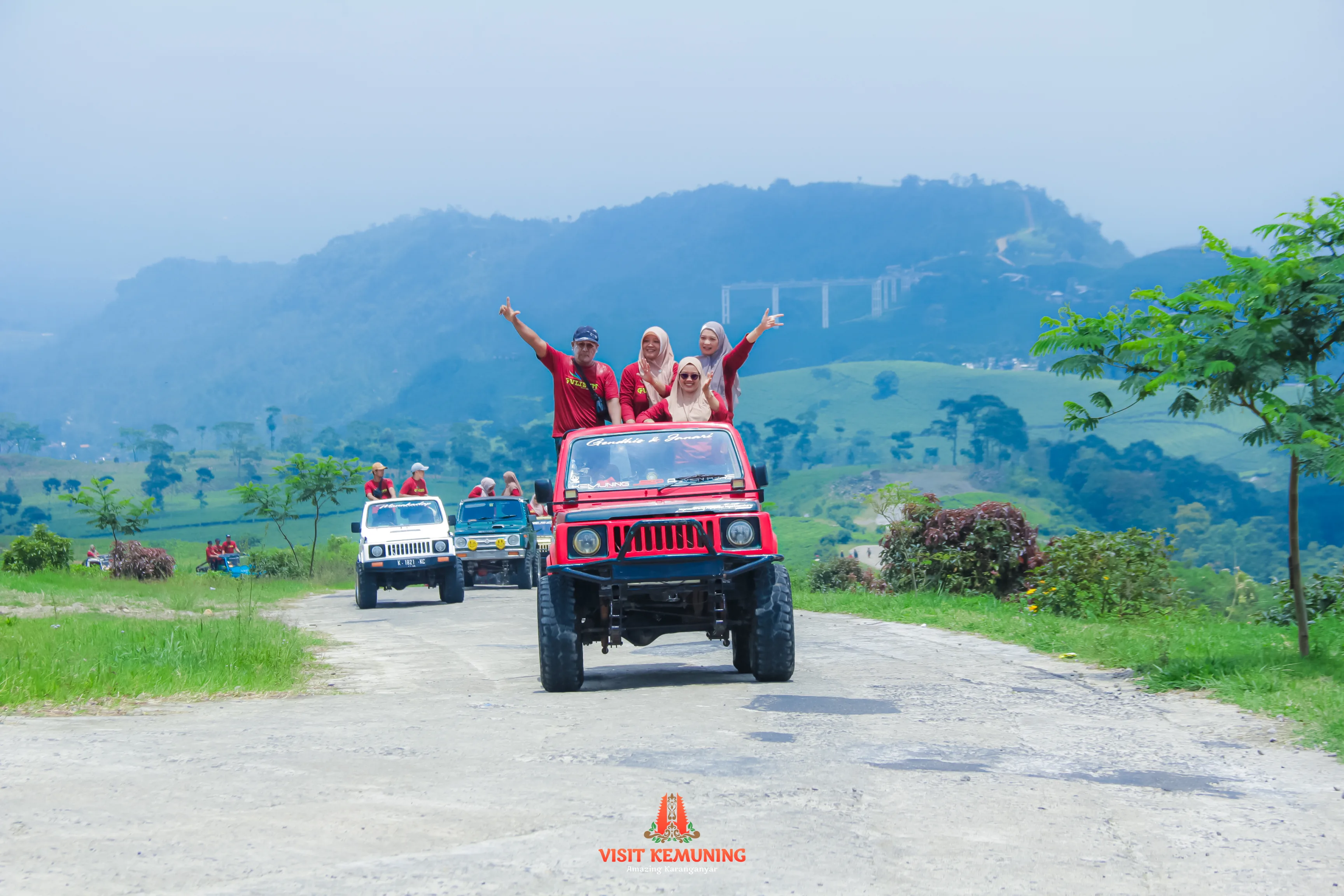 Jeep menyusuri jalur perbukitan dengan latar pemandangan Kemuning